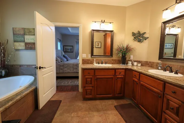 a en suite bathroom with a double vanity sink and a mirror