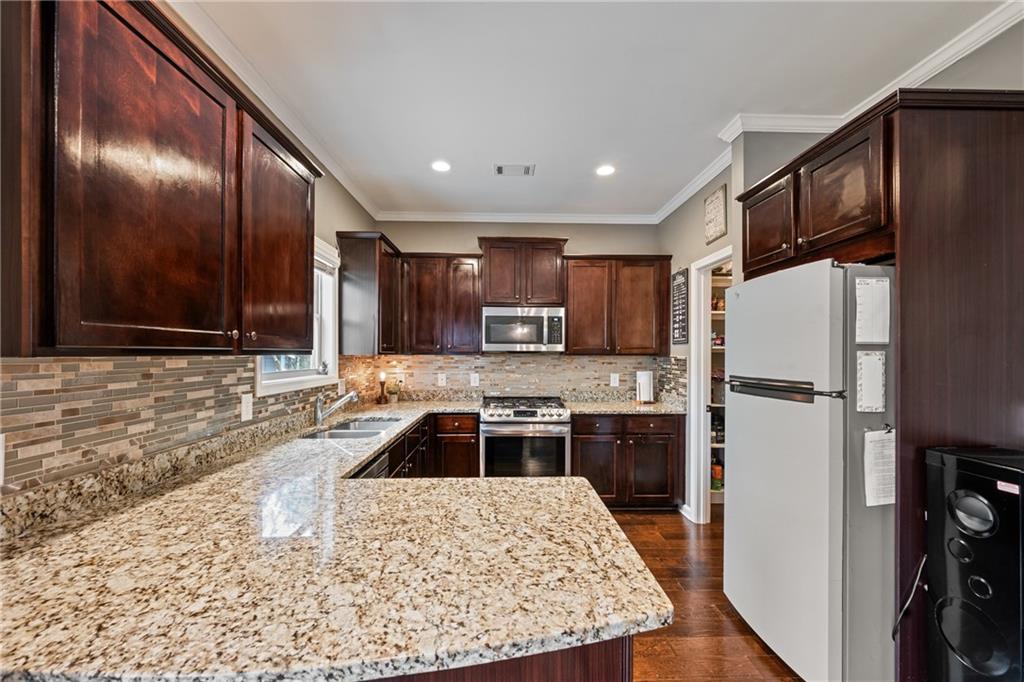 555 Evergreen Way Jefferson, GA 30549 - Photo 23 of 69 a kitchen with stainless steel appliances granite countertop a refrigerator a stove top oven a sink and dishwasher