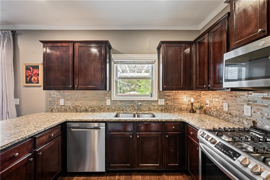 555 Evergreen Way Jefferson, GA 30549 - Photo 26 of 69 a kitchen with stainless steel appliances a sink stove and cabinets
