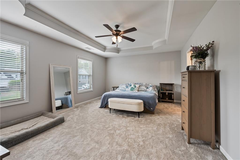 555 Evergreen Way Jefferson, GA 30549 - Photo 33 of 69 a spacious bedroom with a bed and a chandelier