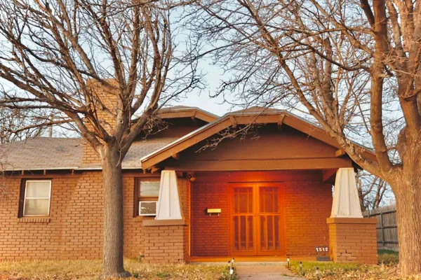 a front view of a house with a tree