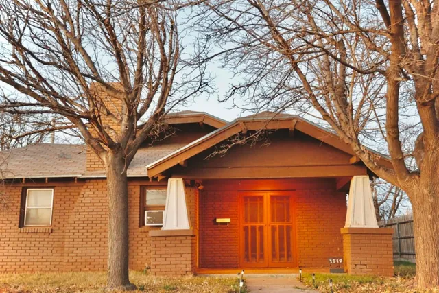 a front view of a house with a tree