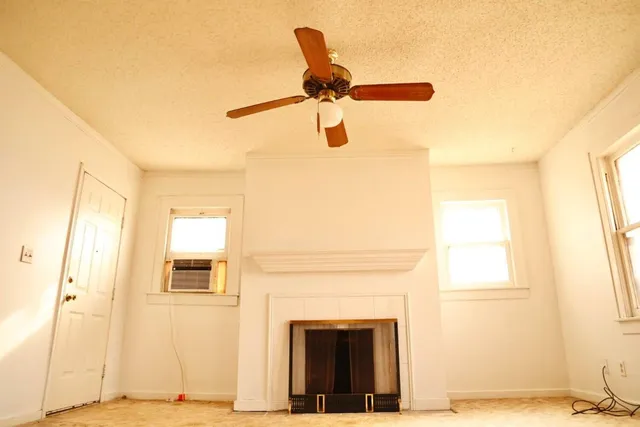 a view of a livingroom with a fireplace and a window