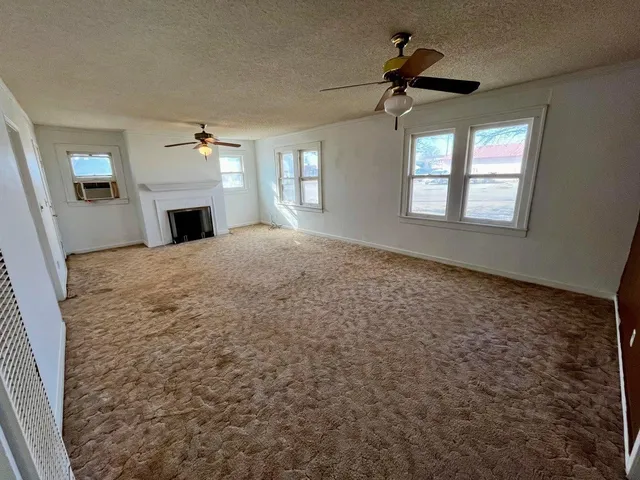 a view of empty room with fireplace and windows