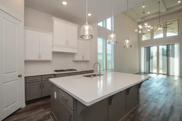 a kitchen with kitchen island a sink appliances and cabinets