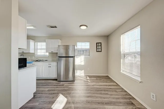 a kitchen with white cabinets and stainless steel appliances