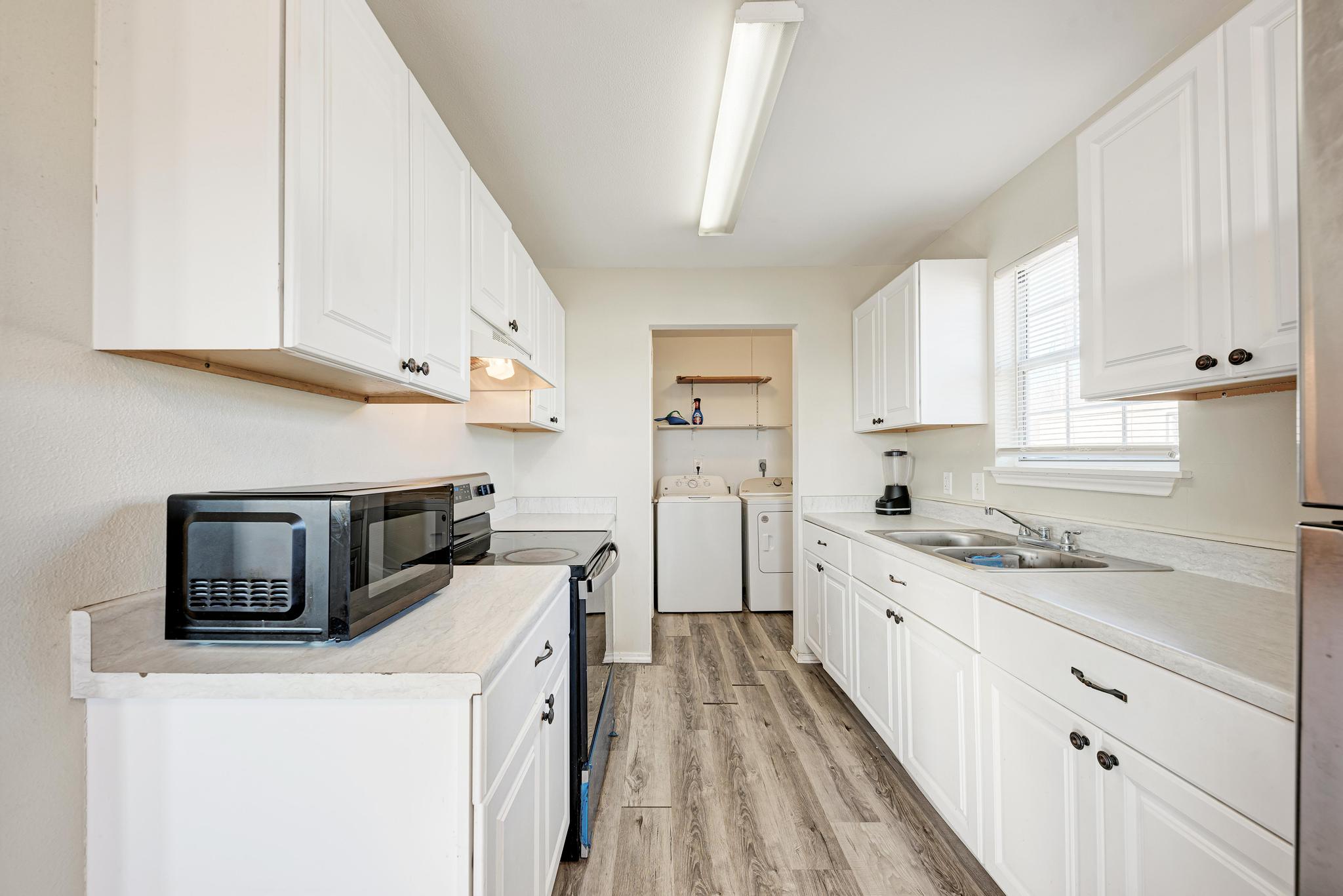 107 West Brenham Street Manor, TX 78653 - Photo 15 of 35 a kitchen with a sink a stove and cabinets