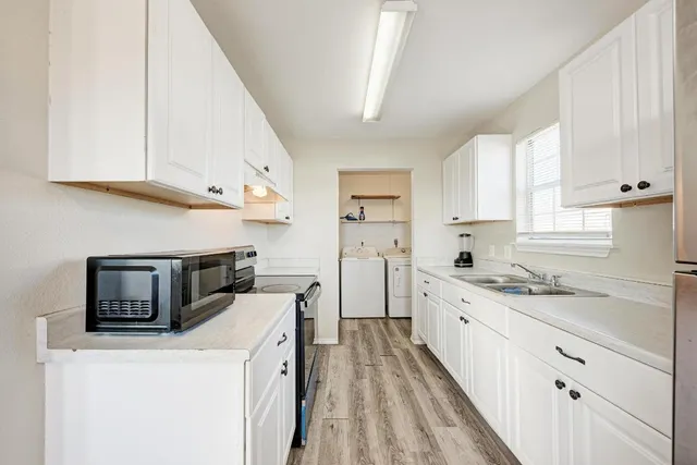 a kitchen with a sink a stove and cabinets