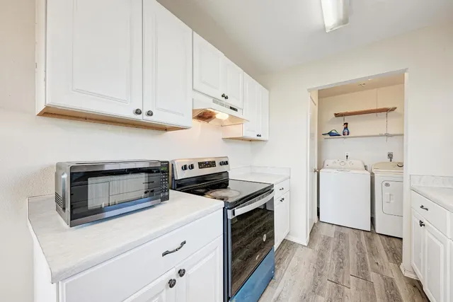 a kitchen with white cabinets and white appliances