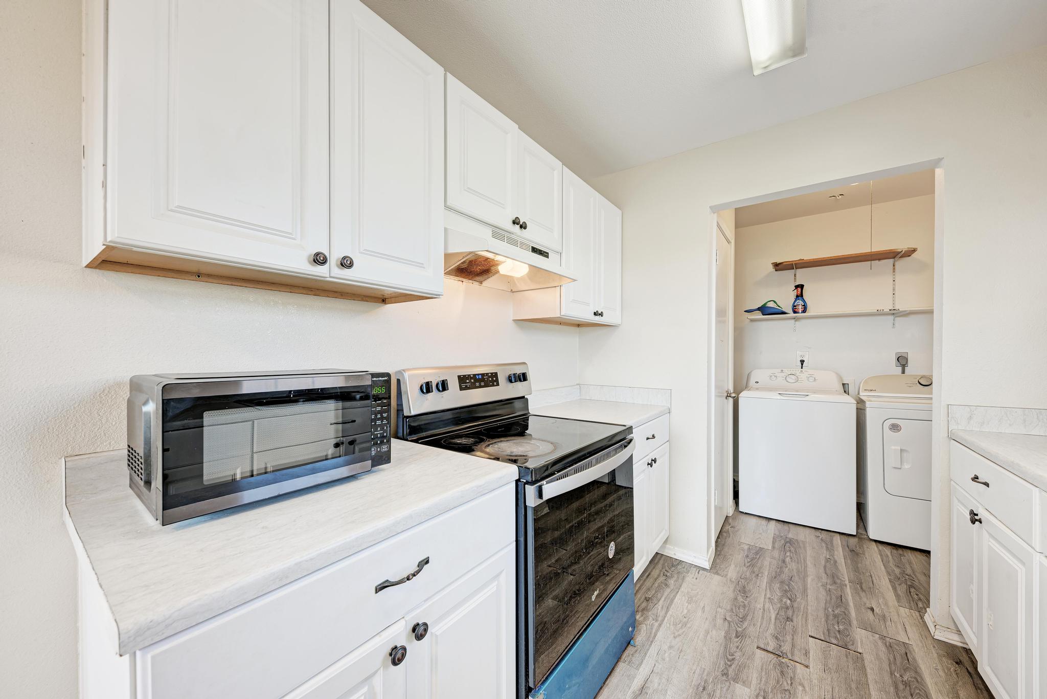 107 West Brenham Street Manor, TX 78653 - Photo 16 of 35 a kitchen with white cabinets and white appliances