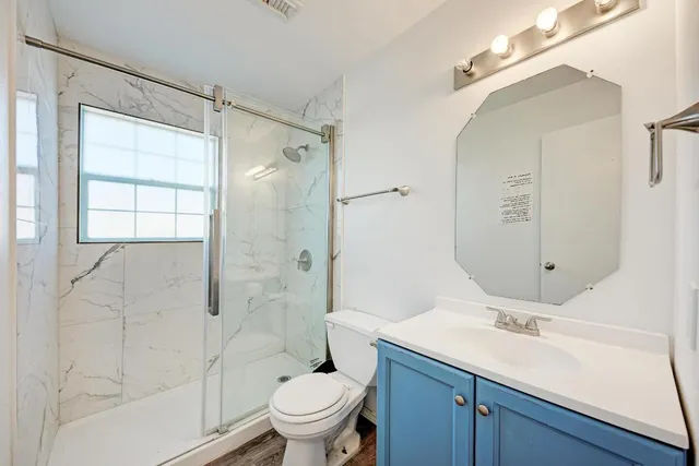 a bathroom with a sink and mirror with toilet