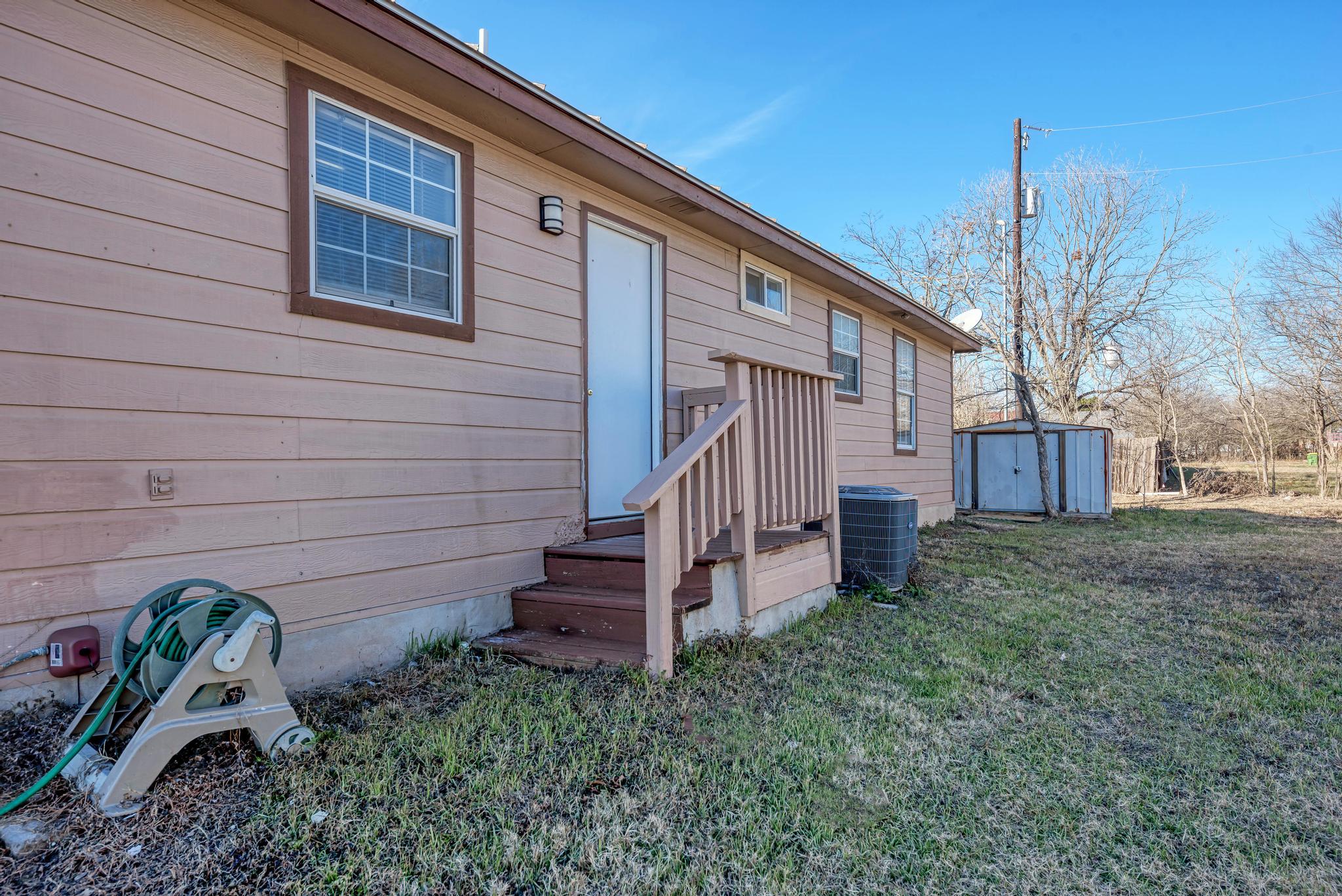 107 West Brenham Street Manor, TX 78653 - Photo 30 of 35 a view of a house with a yard