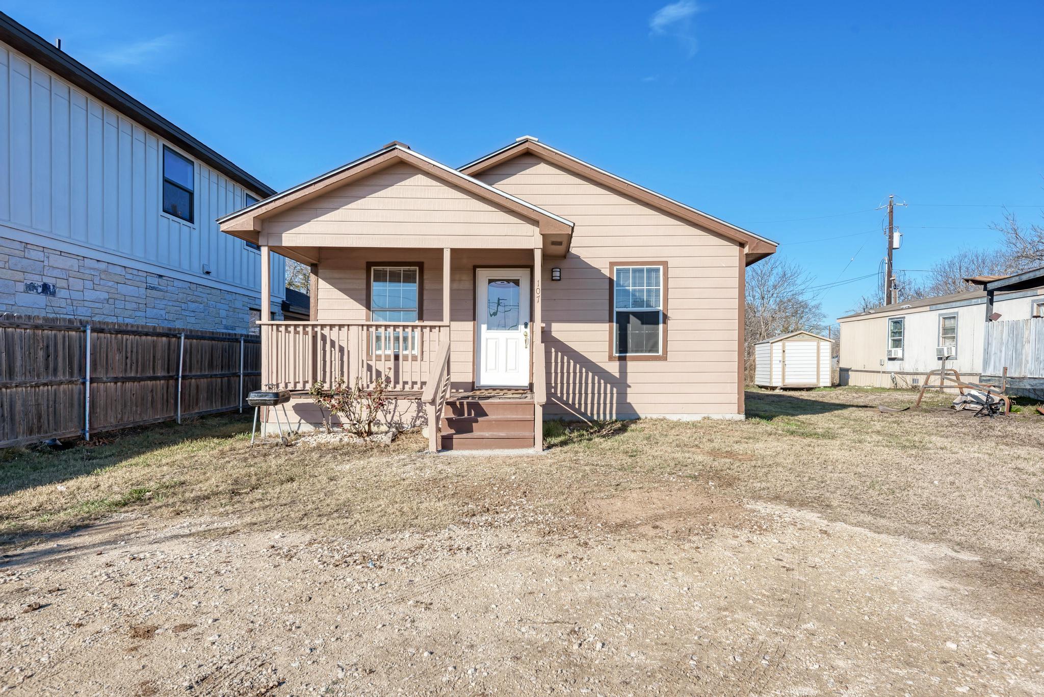 107 West Brenham Street Manor, TX 78653 - Photo 3 of 35 a view of a house with wooden fence