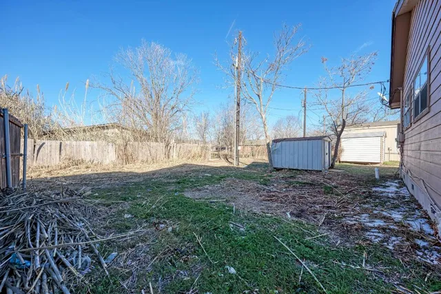 a view of a backyard with large trees and plants