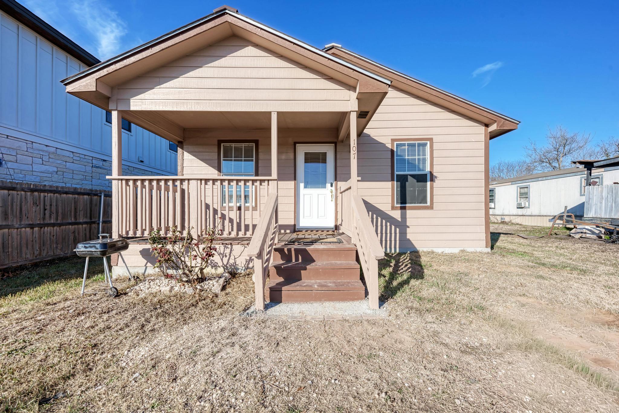 107 West Brenham Street Manor, TX 78653 - Photo 5 of 35 a view of small white house with wooden fence