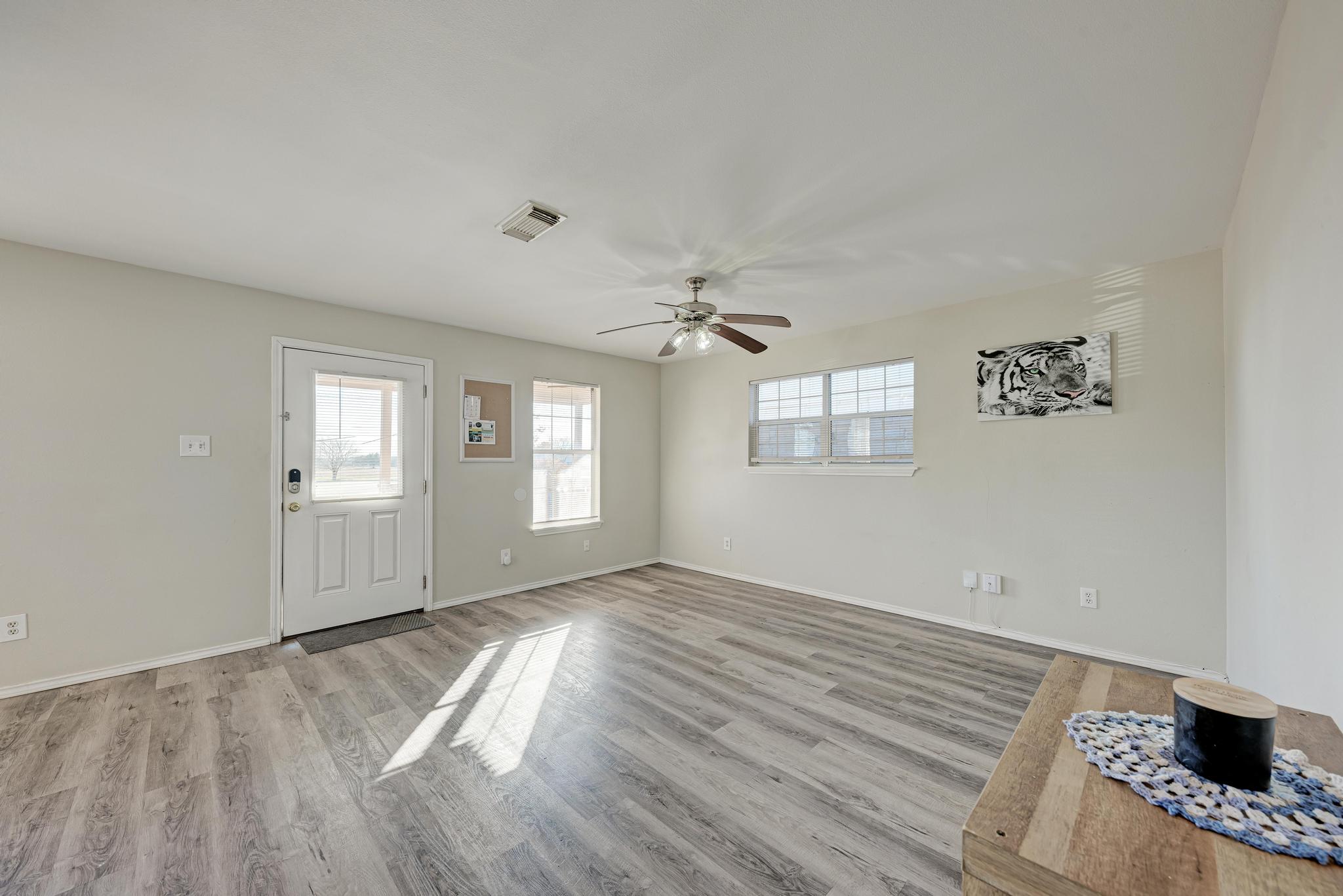 107 West Brenham Street Manor, TX 78653 - Photo 8 of 35 wooden floor in an empty room with a window
