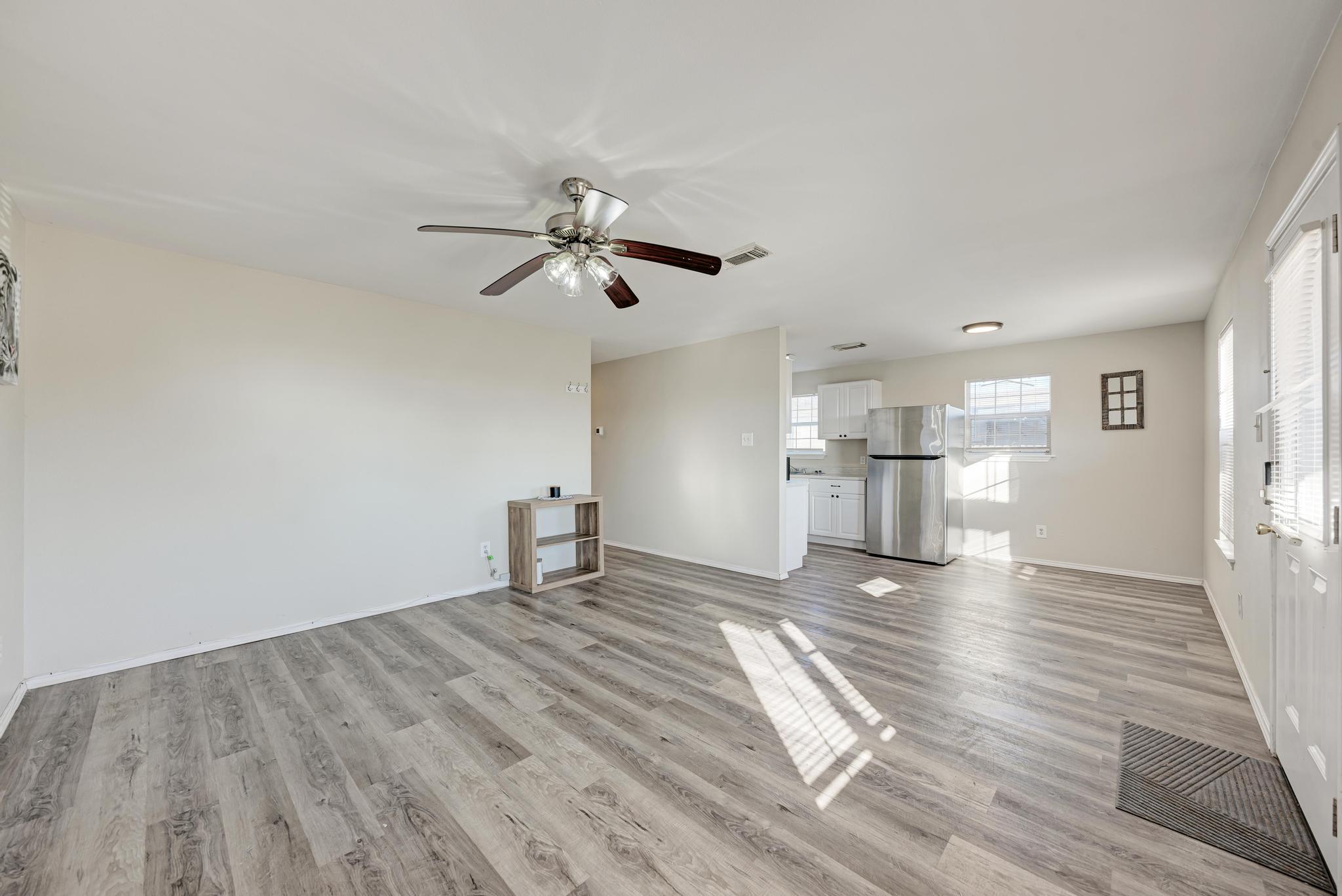 107 West Brenham Street Manor, TX 78653 - Photo 10 of 35 a view of empty room with wooden floor and window