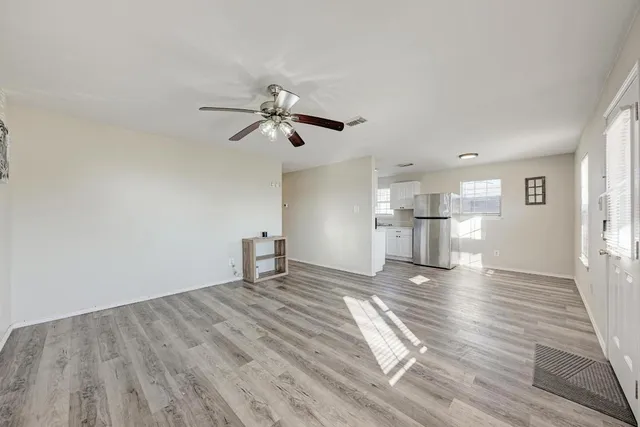 a view of empty room with wooden floor and window