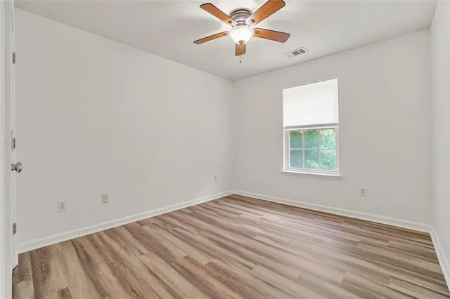 an empty room with a window and a fan