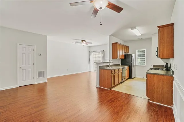 a large kitchen with stainless steel appliances granite countertop a stove top oven a sink with wooden floors