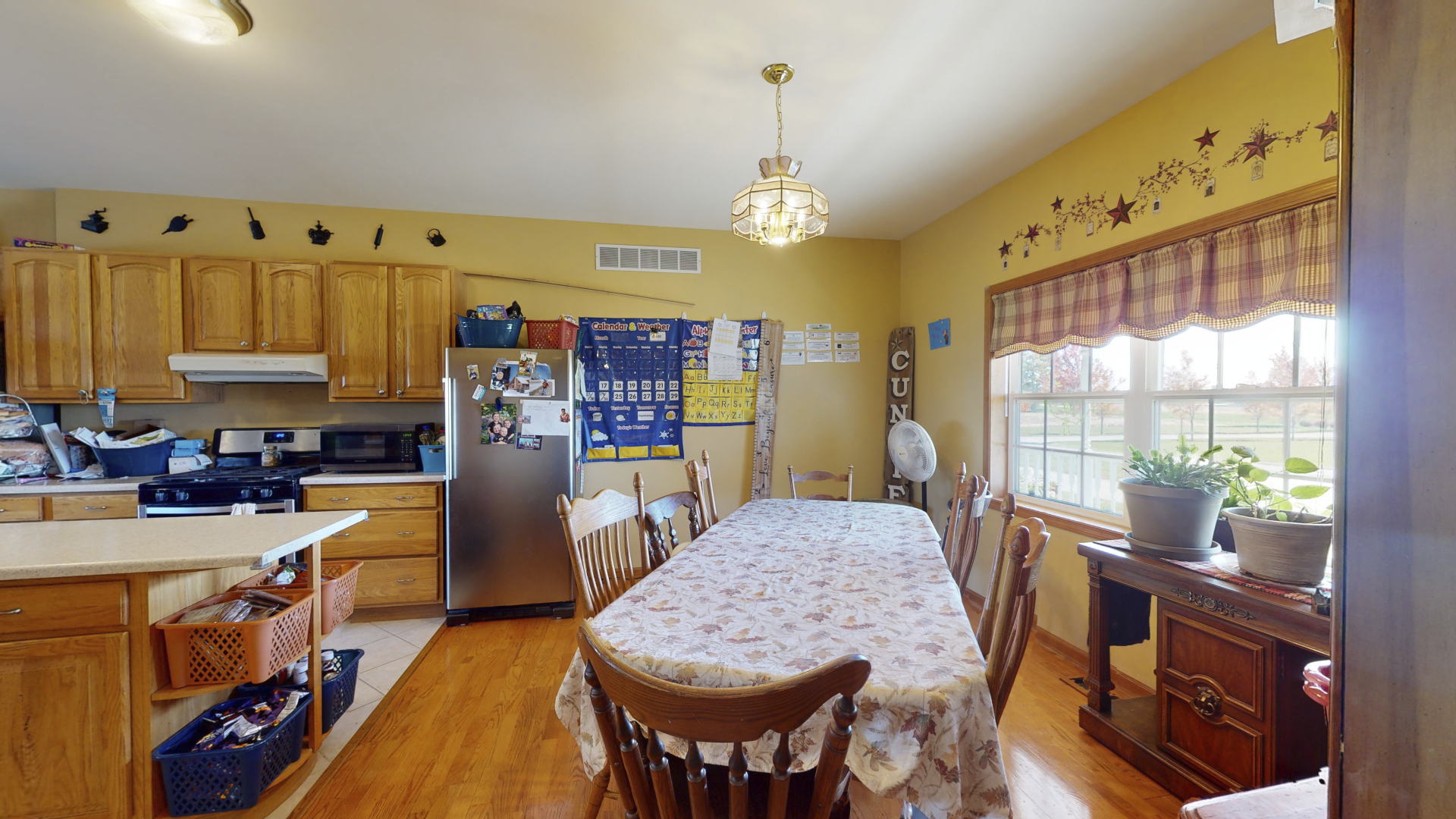 3322 Chicago Road Paw Paw, IL 61353 - Photo 9 of 37 a view of a kitchen with kitchen island a large window cabinets and stainless steel appliances