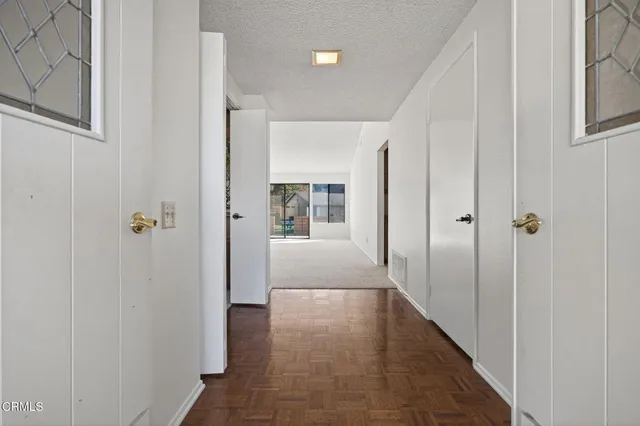 a view of a hallway with wooden floor and closet area