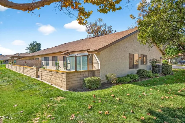 a view of a green field with lots of trees in the background