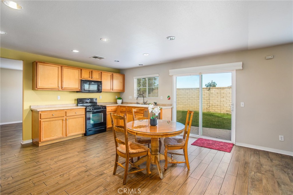 4423 Candelaria Way Perris, CA 92571 - Photo 11 of 42 a kitchen with a table chairs microwave and cabinets
