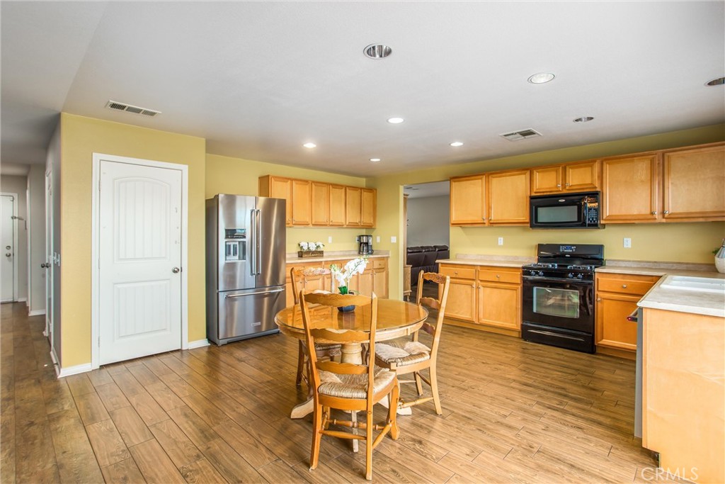 4423 Candelaria Way Perris, CA 92571 - Photo 12 of 42 a kitchen with stainless steel appliances kitchen island granite countertop dining table chairs and granite counter tops