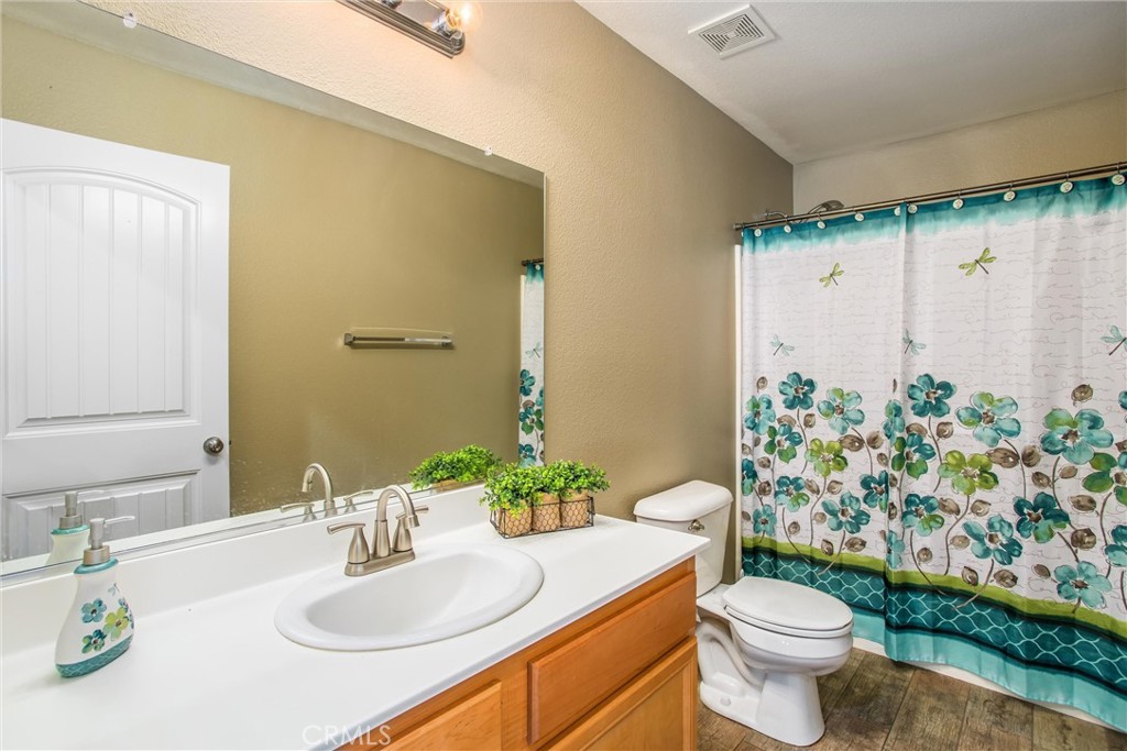 4423 Candelaria Way Perris, CA 92571 - Photo 17 of 42 a bathroom with a granite countertop sink and a mirror