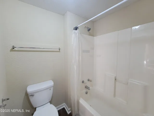 a bathroom with a toilet and a bathtub