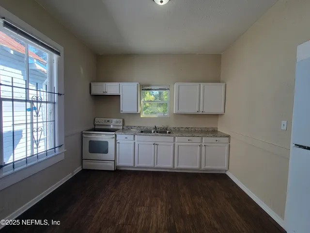a kitchen with granite countertop white cabinets a sink and dishwasher