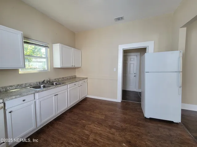 a large kitchen with a refrigerator and a stove top oven