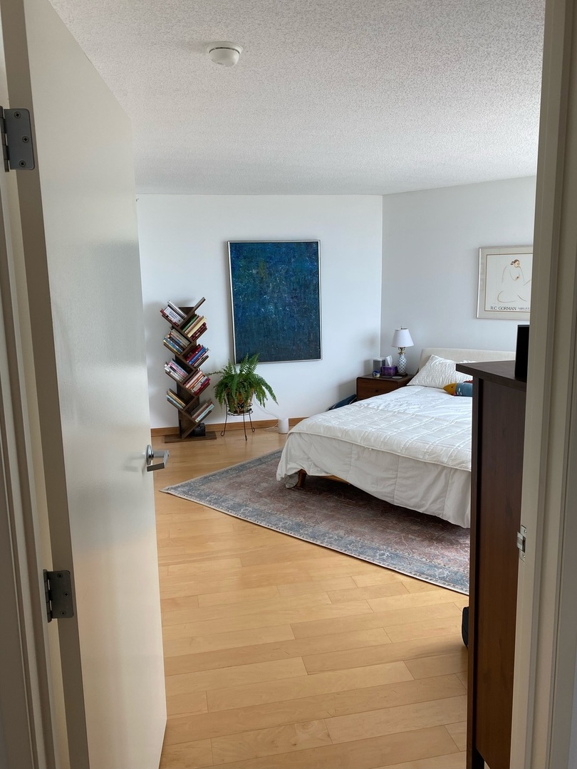 1720 Maple Avenue, Unit 2120 Evanston, IL 60201 - Photo 17 of 21 a bedroom with a bed and a potted plant