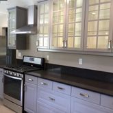 a kitchen with granite countertop a sink a stove and refrigerator