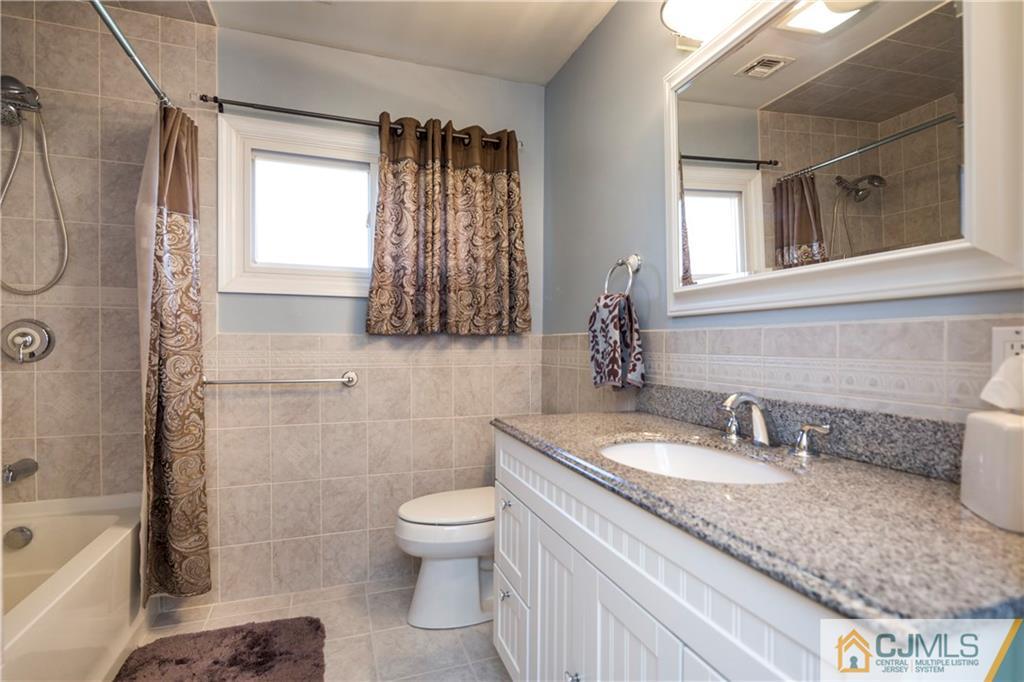 122 Ridge Road Colonia, NJ 07067 - Photo 13 of 25 a bathroom with a granite countertop sink toilet and shower