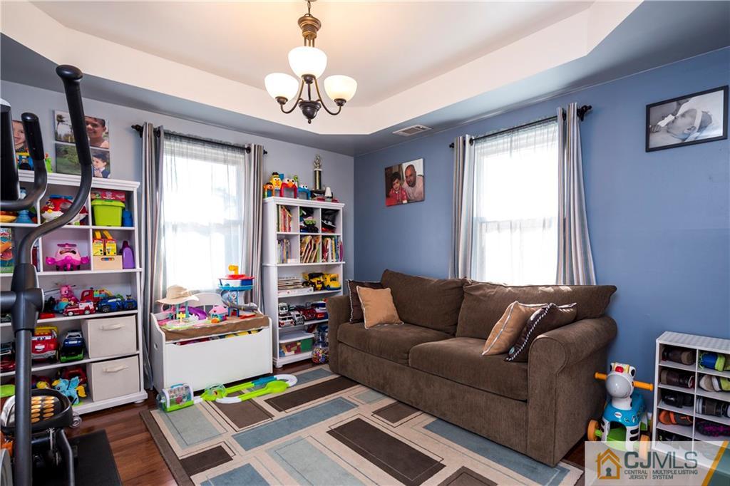 122 Ridge Road Colonia, NJ 07067 - Photo 15 of 25 a living room with furniture and a book shelf
