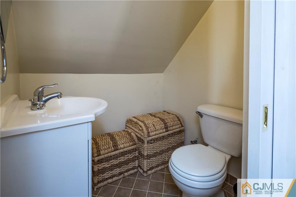 122 Ridge Road Colonia, NJ 07067 - Photo 18 of 25 a bathroom with a toilet a sink and mirror