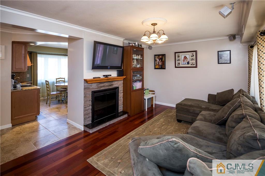 122 Ridge Road Colonia, NJ 07067 - Photo 4 of 25 a living room with furniture a fireplace and a chandelier