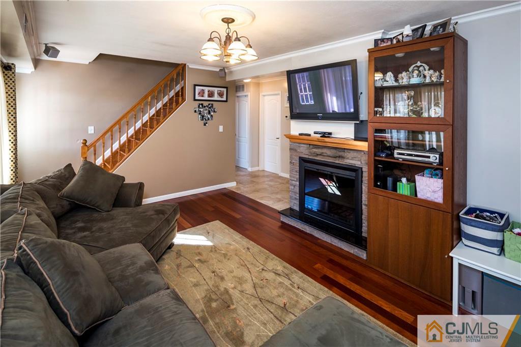122 Ridge Road Colonia, NJ 07067 - Photo 6 of 25 a living room with furniture a bookshelf and a fireplace