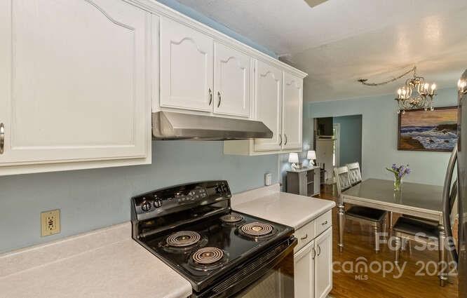 1411 Bailey Branch Road Burnsville, NC 28714 - Photo 12 of 40 a kitchen with a stove and a white cabinets