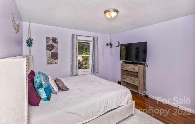 1411 Bailey Branch Road Burnsville, NC 28714 - Photo 15 of 40 a bedroom with a bed and a flat screen tv