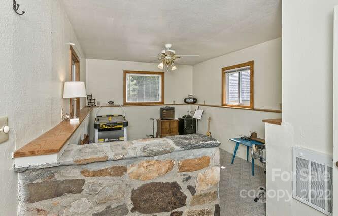 1411 Bailey Branch Road Burnsville, NC 28714 - Photo 31 of 40 a kitchen with granite countertop a stove a sink a dining table and chairs