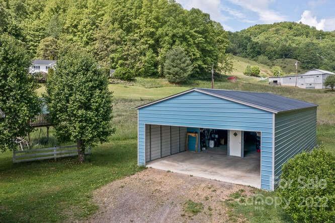 1411 Bailey Branch Road Burnsville, NC 28714 - Photo 35 of 40 a view of a house with a yard and large tree