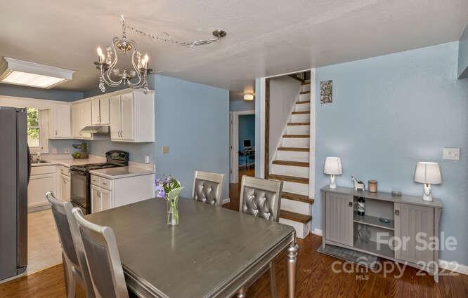 1411 Bailey Branch Road Burnsville, NC 28714 - Photo 10 of 40 a kitchen with a dining table chairs and refrigerator