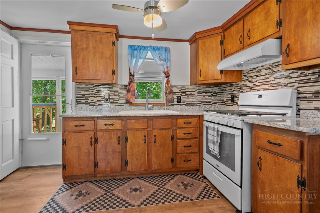 154 Folger Road Sparta, NC 28675 - Photo 5 of 37 a kitchen with stainless steel appliances granite countertop a stove a sink and a cabinets