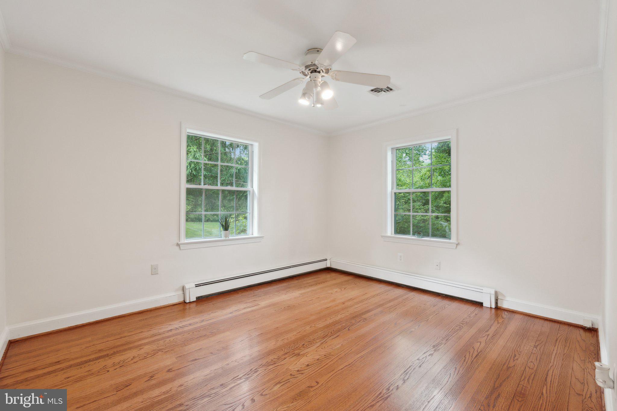 701 Notley Road Silver Spring, MD 20904 - Photo 34 of 60 an empty room with wooden floor chandelier fan and windows