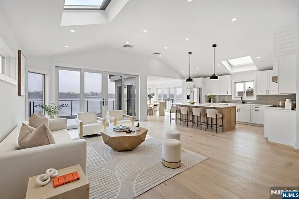 a living room with lots of furniture and a view of kitchen appliances