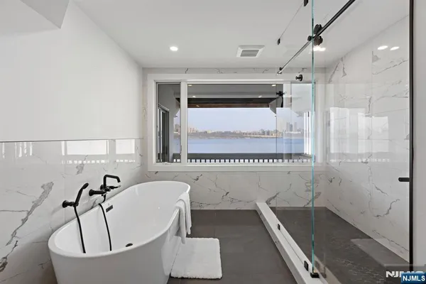 a bathroom with a tub a sink and a shower