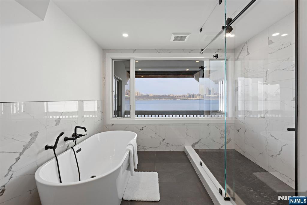 27 Shore Road Edgewater, NJ 07020 - Photo 34 of 48 a bathroom with a tub a sink and a shower